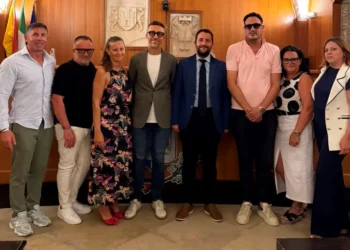 L'assessore regionale Francesco Colianni posa con il sindaco Gianfranco Fidone, amministratori comunali e rappresentanti dell'amministrazione nella sala del Consiglio comunale di Acate durante una visita istituzionale.