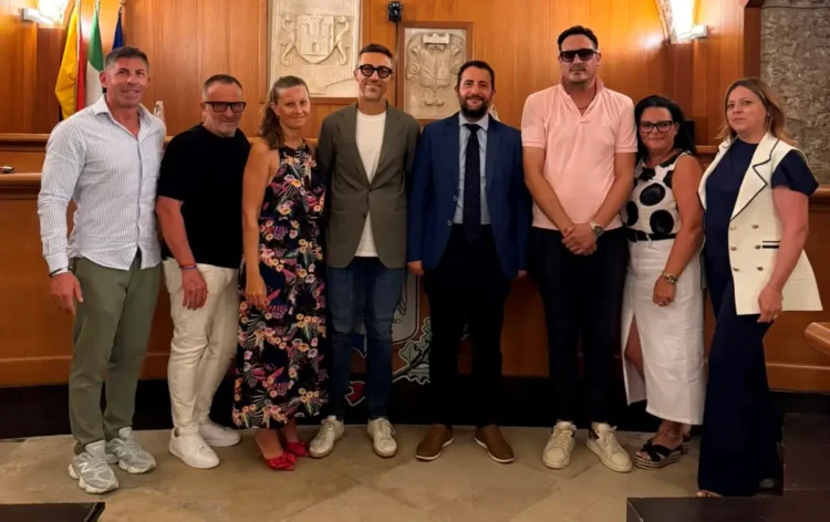 L'assessore regionale Francesco Colianni posa con il sindaco Gianfranco Fidone, amministratori comunali e rappresentanti dell'amministrazione nella sala del Consiglio comunale di Acate durante una visita istituzionale.