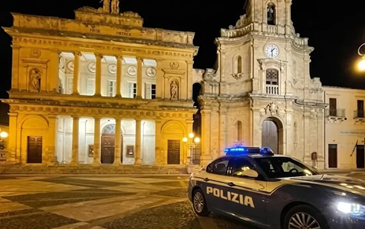 Auto della Polizia di Stato davanti alla Basilica di San Giovanni Battista e al Teatro Comunale di Vittoria durante l'esecuzione di un ordine di carcerazione.