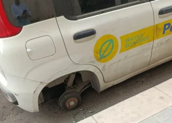 Auto di servizio delle Poste senza una ruota, parcheggiata davanti all'ufficio postale di Vittoria dopo il furto
