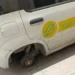 Auto di servizio delle Poste senza una ruota, parcheggiata davanti all'ufficio postale di Vittoria dopo il furto