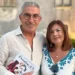 Salvatore Battaglia e Salvatrice Corallo posano insieme tenendo in mano il libro "Raccontami di te" davanti a un edificio in pietra.