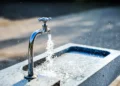 Rubinetto con acqua corrente su una vasca in pietra
