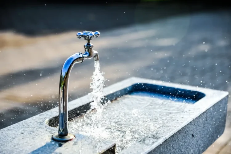 Rubinetto con acqua corrente su una vasca in pietra