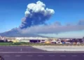 Colonna di cenere e fumo dell'Etna si alza sopra Catania, con l'area aeroportuale in primo piano