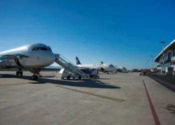 Pista dell'aeroporto di Comiso con due aerei di linea in sosta davanti al terminal, cielo sereno.