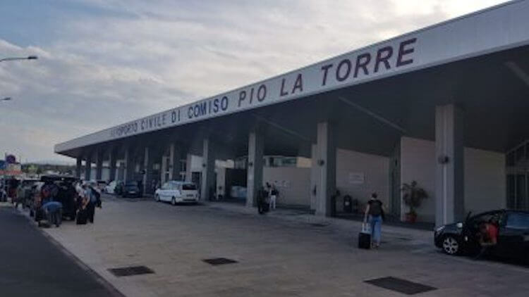 Ingresso del terminal dell'Aeroporto Civile di Comiso Pio La Torre con passeggeri e auto in sosta