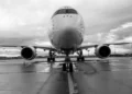 Vista frontale di un aereo di linea fermo in pista, carrelli a terra, cielo nuvoloso