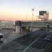 Piazzale aeroportuale con torre di controllo, passerella d'imbarco e aereo Ryanair in sosta al tramonto