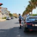 Due auto dei Carabinieri e due militari in uniforme durante un controllo su una strada alberata di Ragusa.