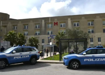 Due volanti della Polizia di Stato parcheggiate davanti all'ingresso di un ospedale, con la lettera H rossa in facciata.