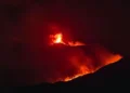 Eruzione notturna dell’Etna con fontane di lava e bagliore rosso sulla zona sommitale.