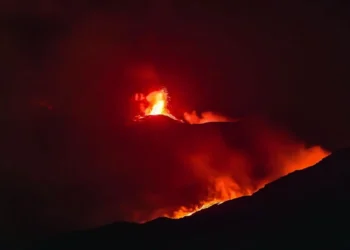Eruzione notturna dell’Etna con fontane di lava e bagliore rosso sulla zona sommitale.