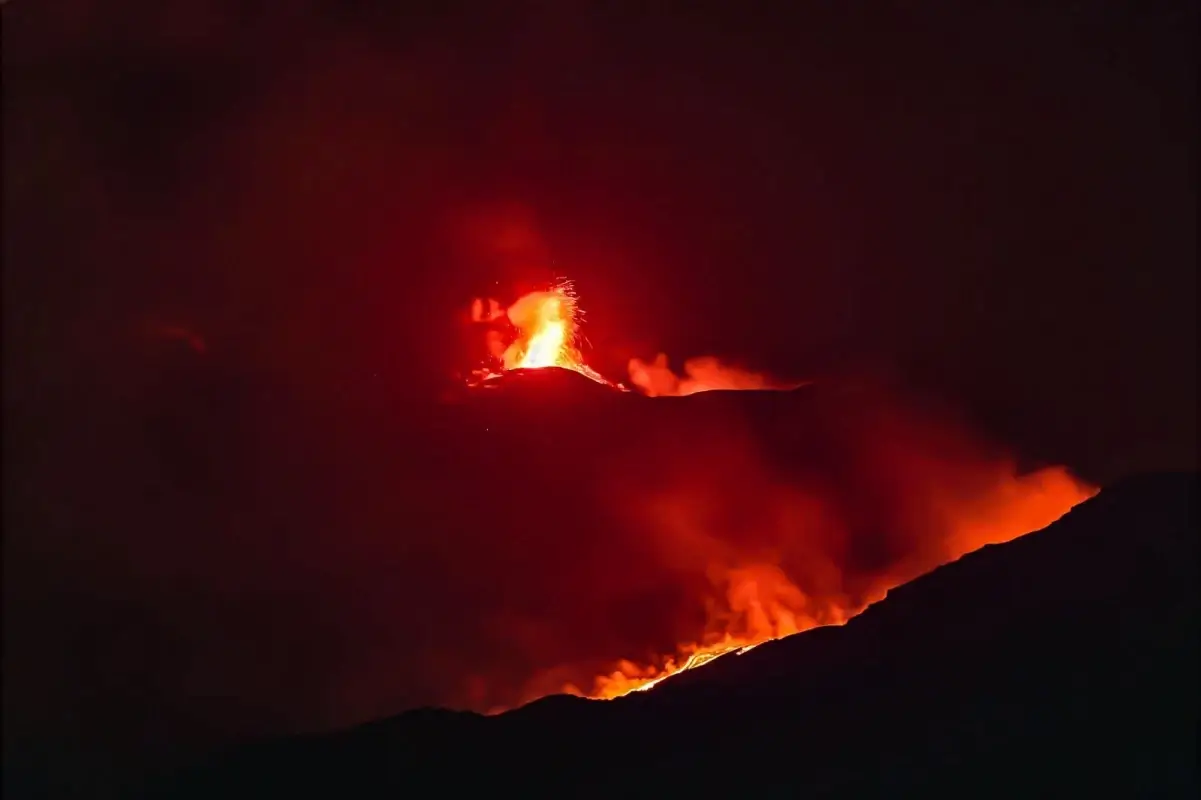 Eruzione notturna dell’Etna con fontane di lava e bagliore rosso sulla zona sommitale.