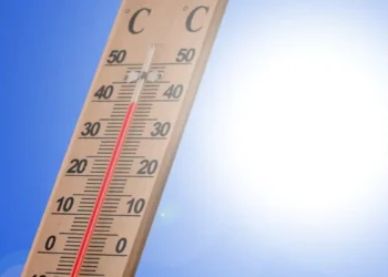 Termometro da esterno con la colonnina di mercurio sopra i 40 gradi, cielo azzurro e sole intenso sullo sfondo.