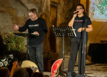 Amedeo Fusco, con microfono ad archetto e maglietta nera con la scritta "Viva la vida!", e la cantante Rossella Marino, in abito coordinato, sul palco allestito in piazza Spirito Santo a Cariati