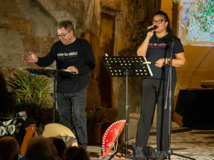 Amedeo Fusco, con microfono ad archetto e maglietta nera con la scritta "Viva la vida!", e la cantante Rossella Marino, in abito coordinato, sul palco allestito in piazza Spirito Santo a Cariati