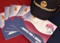 Opuscoli della campagna Polizia di Stato «...questo NON è AMORE» accanto a un berretto da agente, su sfondo rosso