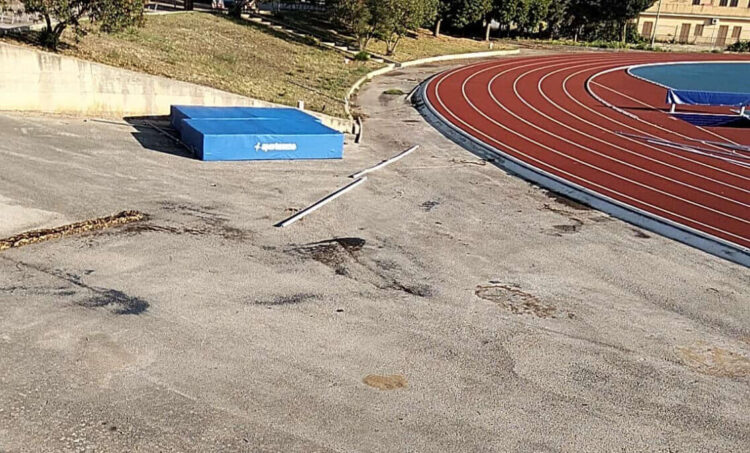 Materasso del salto in alto spostato e aste a terra accanto alla pista di atletica di Ragusa