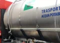 Autobotte con cisterna in acciaio per il trasporto di acqua potabile, vista laterale con tubi e rubinetti di erogazione