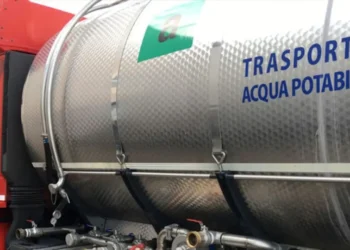 Autobotte con cisterna in acciaio per il trasporto di acqua potabile, vista laterale con tubi e rubinetti di erogazione