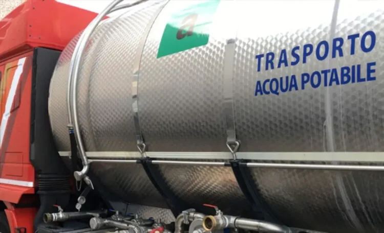 Autobotte con cisterna in acciaio per il trasporto di acqua potabile, vista laterale con tubi e rubinetti di erogazione
