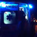 Ambulanza di notte con portellone aperto e luci blu accese durante un intervento di emergenza del 118