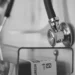 Uno stetoscopio appeso a una parete accanto a una scatola di guanti monouso, in un ambulatorio medico