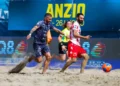 Due giocatori di beach soccer si contendono il pallone sulla sabbia durante una gara ufficiale ad Anzio