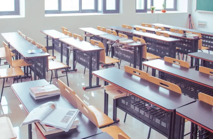 Aula scolastica vuota con banchi e sedie disposti in file