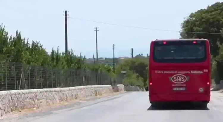 Autobus SAIS Autolinee rosso di spalle su strada provinciale verso Marina di Modica, vegetazione mediterranea ai lati