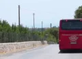 Autobus rosso SAIS Autolinee di spalle su strada di campagna con muretti a secco, diretto verso Marina di Modica