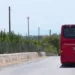 Autobus rosso SAIS Autolinee di spalle su strada di campagna con muretti a secco, diretto verso Marina di Modica