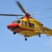 Elicottero del 118 giallo e rosso in volo su cielo azzurro, impiegato per il trasporto di un paziente in emergenza