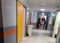 Corridoio dell'ospedale con un'ambulanza visibile all'ingresso e due persone sullo sfondo.