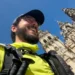 Antonio Giannone con zaino e bastoni sorride davanti alla cattedrale di Santiago de Compostela in una giornata di sole