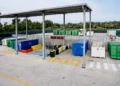 Container colorati per la raccolta differenziata disposti sotto una tettoia in un centro di raccolta rifiuti
