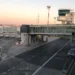 Pista dell'aeroporto di Catania-Fontanarossa con torre di controllo, aerei e passerella d'imbarco al tramonto