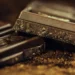 Tavolette di cioccolato fondente spezzate su polvere di cacao, con grana irregolare visibile sul bordo di frattura