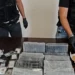 Panetti di cocaina avvolti in cellophane su un tavolo, affiancati da due kit narcotest Multi-Drug Test Panel e banconote in euro