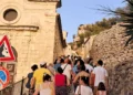 Un gruppo di persone risale una stradina in pietra durante la visita guidata sul Colle di San Matteo a Scicli