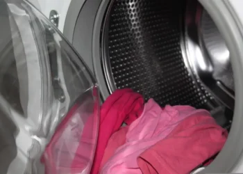 Interno di una lavatrice a carica frontale con capi rosa nel cestello