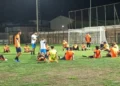 Giocatori del Comiso seduti in cerchio sul campo dello stadio comunale durante l'allenamento serale precampionato