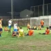 Giocatori del Comiso seduti in cerchio sul campo dello stadio comunale durante l'allenamento serale precampionato