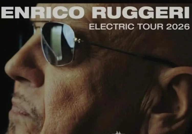 Primo piano di Enrico Ruggeri con occhiali da sole, locandina con scritta Electric Tour 2026.