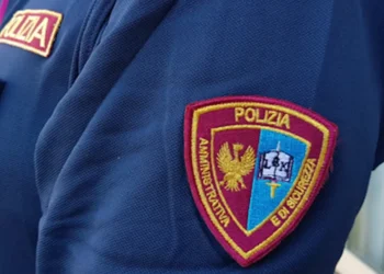 Patch sul braccio di una divisa della Polizia Amministrativa e di Sicurezza, con stemma dorato su sfondo bicolore bordeaux e azzurro