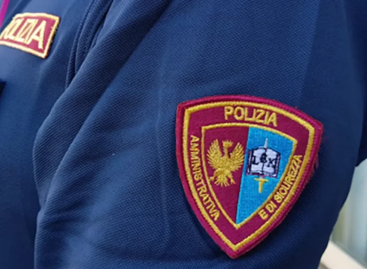Patch sul braccio di una divisa della Polizia Amministrativa e di Sicurezza, con stemma dorato su sfondo bicolore bordeaux e azzurro