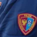 Patch sul braccio di una divisa della Polizia Amministrativa e di Sicurezza, con stemma dorato su sfondo bicolore bordeaux e azzurro