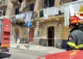 Vigile del fuoco davanti al palazzo di via Emiliani Giudici a Palermo con i detriti del balcone crollato