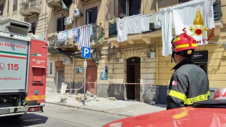 Vigile del fuoco davanti al palazzo di via Emiliani Giudici a Palermo con i detriti del balcone crollato